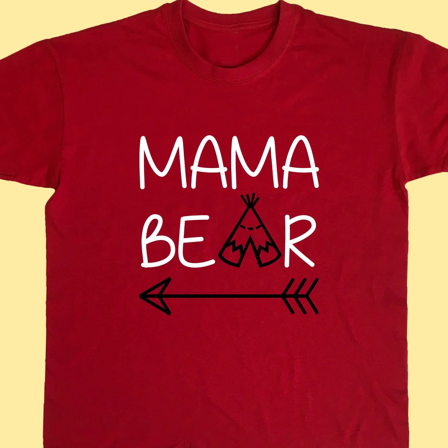 Red adult t shirt with top line of text reading Mama and the second reading bear but with the a replaced with a teepee and an arrow under the whole design. Printed in two colours text printed in white and teepee and arrow in black.