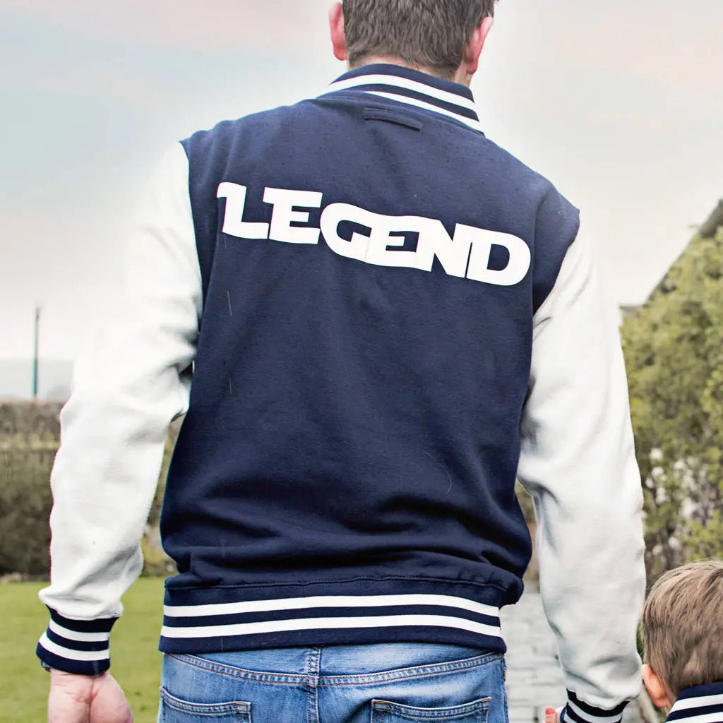 Man wearing a Navy varsity jacket with white sleeves and Legend printed on the back