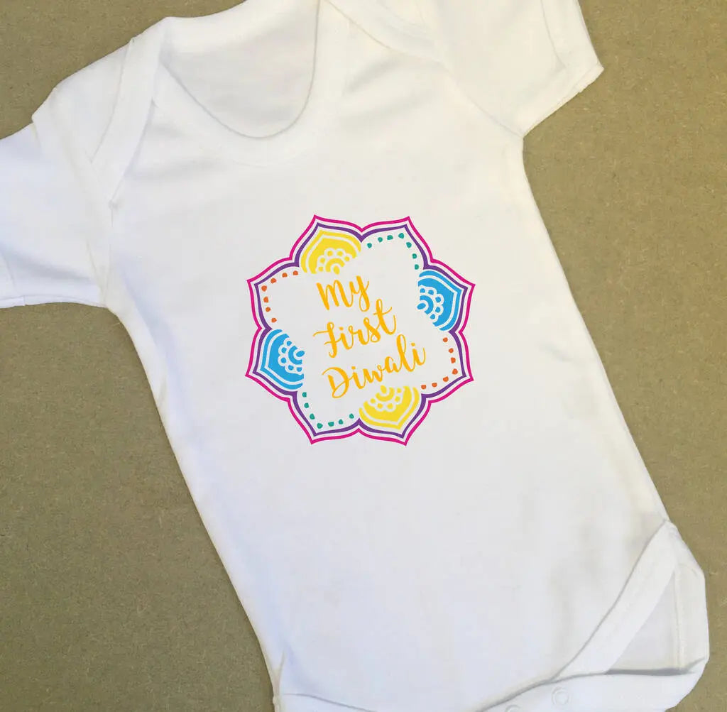 White babygrow with a colourful mandala design and the text my first diwali in the centre.