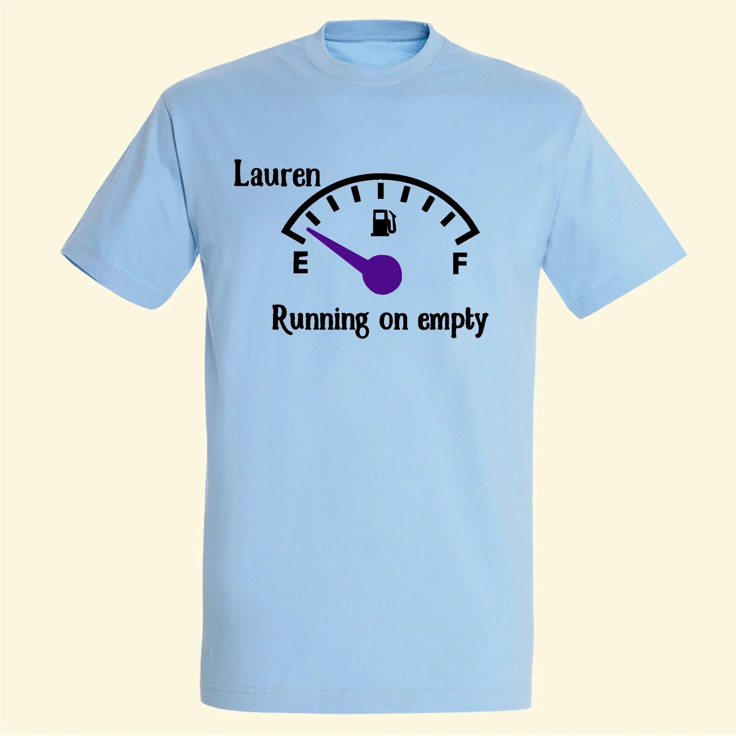 Light blue t shirt with a fuel type dial with an E at the lowest point and F at the highest point, the dial is on E, with the text running on empty below the dial and who is running on empty name printed on the front