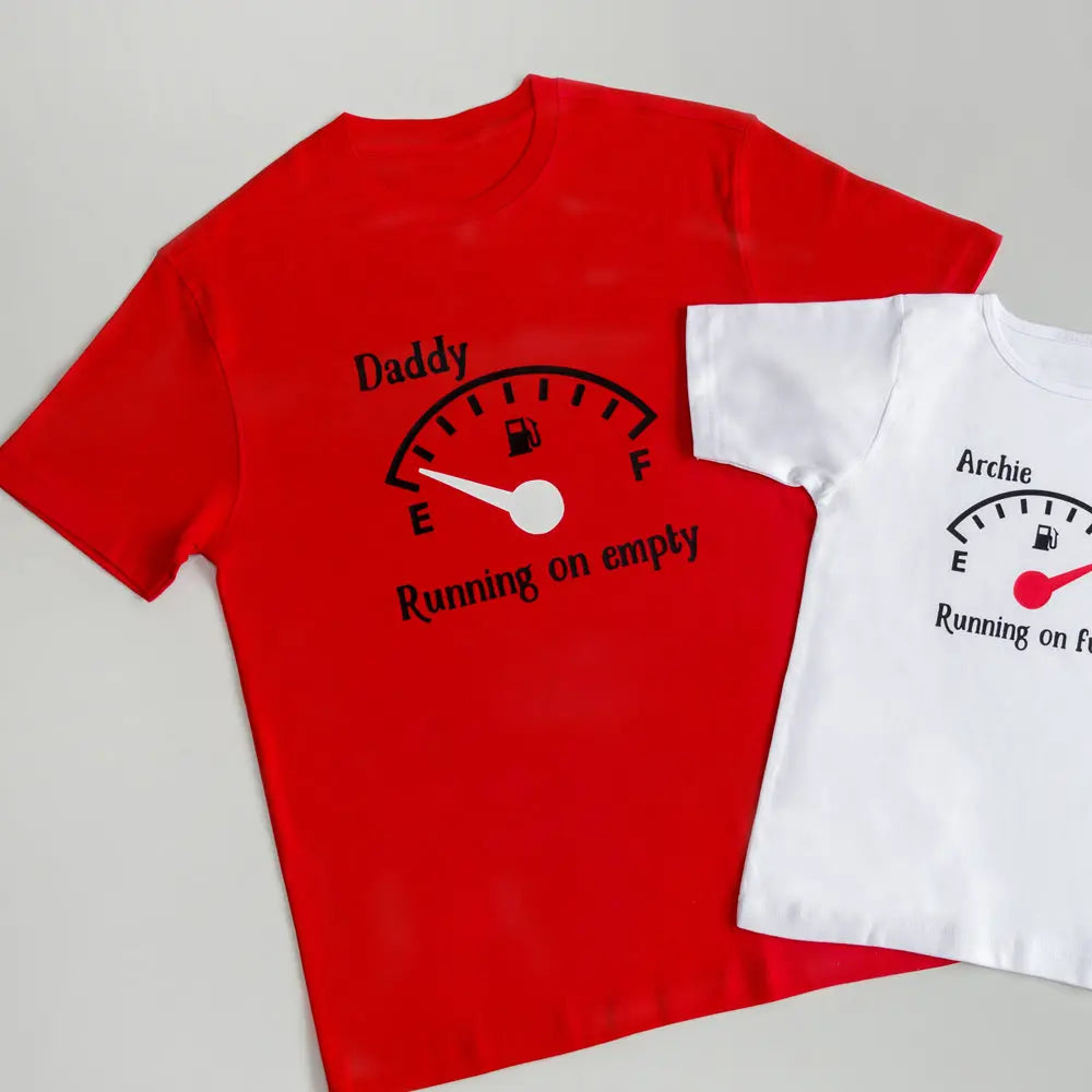 Daddy running on empty t shirt in red with black petrol style gauge with a white dial pointing to E. Next to the Dad's t shirt is a partial view of a white kids running on full t shirt