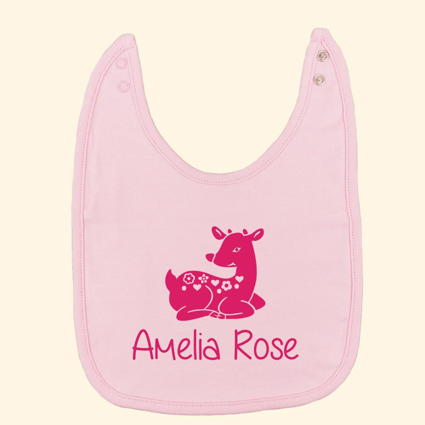 Light pink bib with a cute baby deer illustration and the name Amelia Rose printed below all in fuchsia pink.