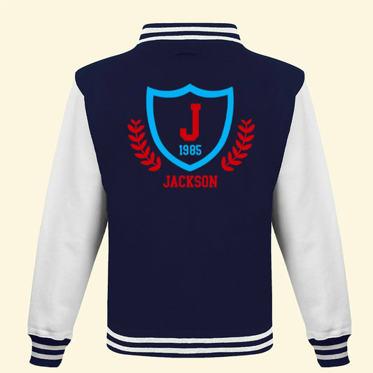 Navy Varsity Jacket, with White sleeves. Printed with a college logo of a shield and leafs on the back with the name Jackson, J and year 1985.