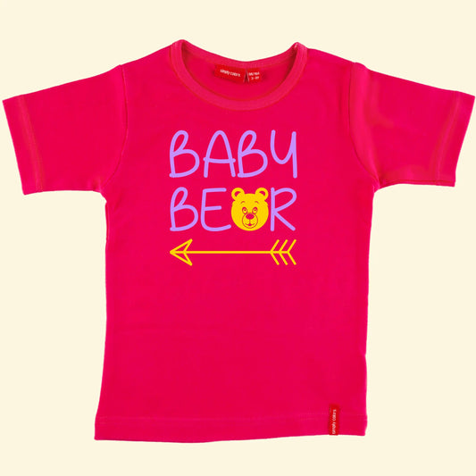 Kids pink t shirt with top line of text reading Baby and the second reading bear but with the a replaced with a bear face and an arrow under the whole design, text printed in lilac and bear /  arrow in yellow.