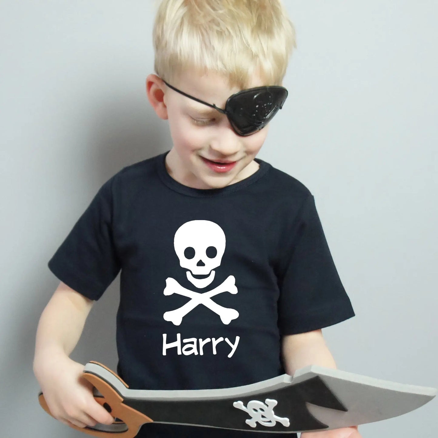 Navy t shirt with a scull and cross bones printed with the name Harry in editable pet below., all printed in white.