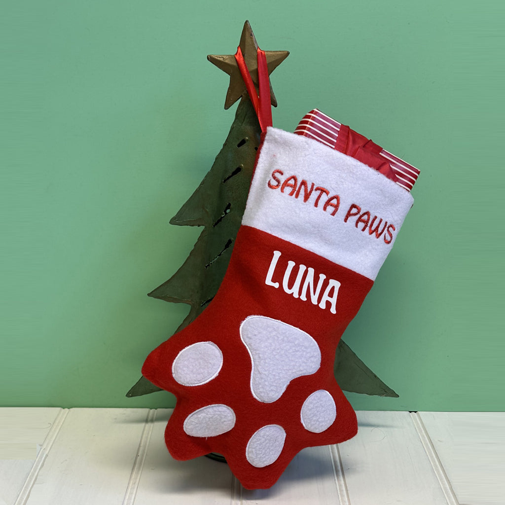 Red and white Christmas stocking with the bottom half in the shape of a paw with white applique. Santa Paws embroidered in red on the white trim and Luna printed in white underneath trim.  