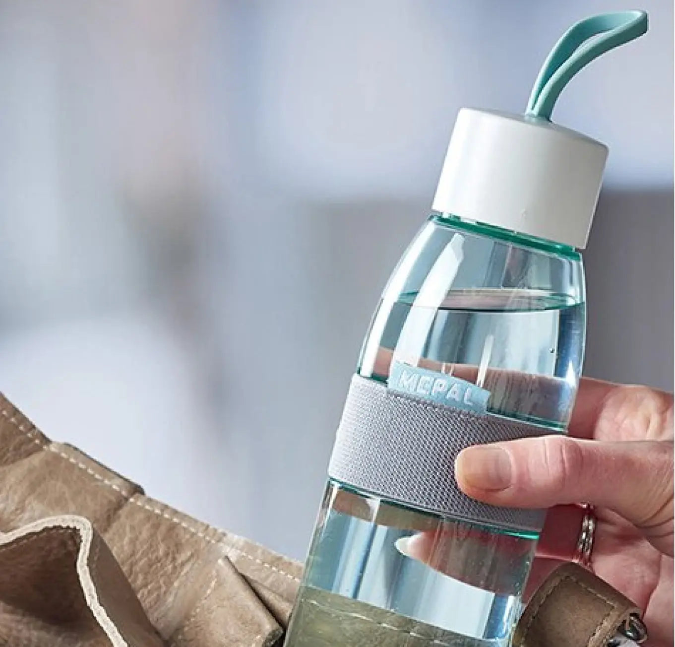 Close-up of nordic green Ellipse water bottle, showing the handle on the lid and grip band around the bottle