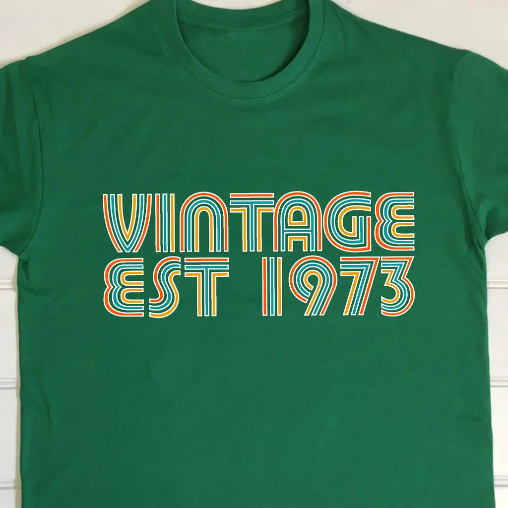 Green t shirt with Vintage EST 1973 printed on the front in a colourful retro style