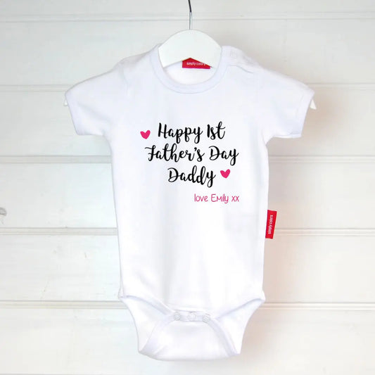 White bodysuit with design that reads Happy 1st Father's Day Daddy printed in black and love Emily xx with two hearts printed in fuchsia pink.