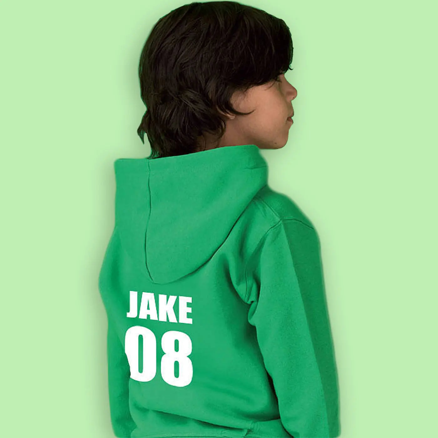 Child wearing a green hoodie with the name Jake and 08 printed on the back in white. The boy is against a light green background