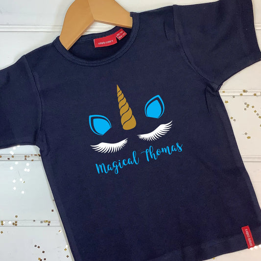 Kids navy t shirt with Magical Thomas printed below white eyelashes (only on navy t shirts), golden horn in the middle of two blue ears matching the text.