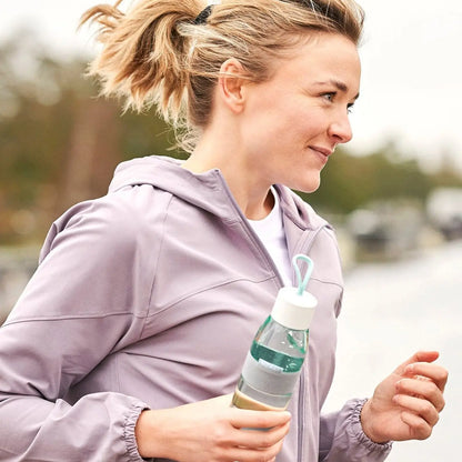 Women running with a nordic green ellipse water bottle in her hand