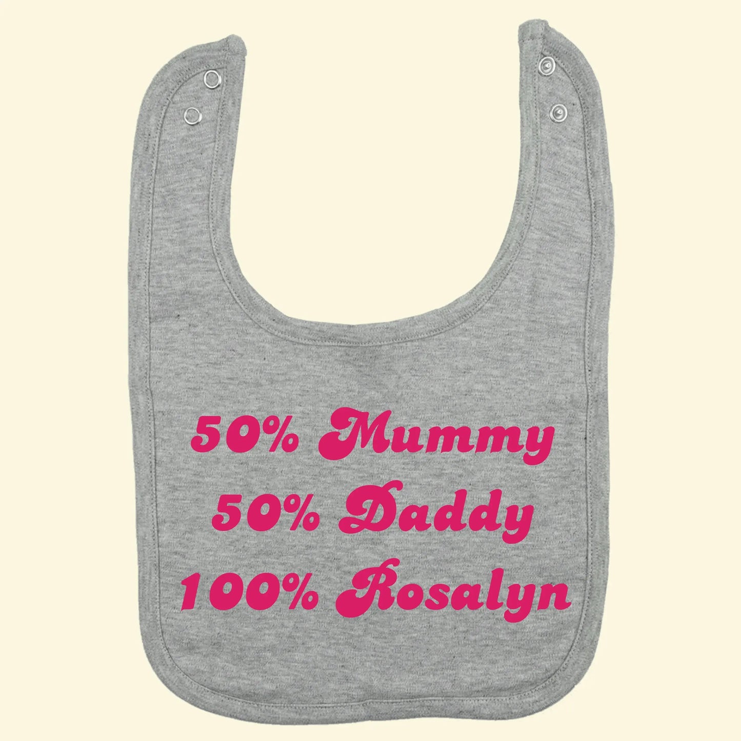 Grey bib with three lines of text reading
50% Mummy
50% Daddy
100% Rosalyn

Printed in fuchsia pink, Candice font.