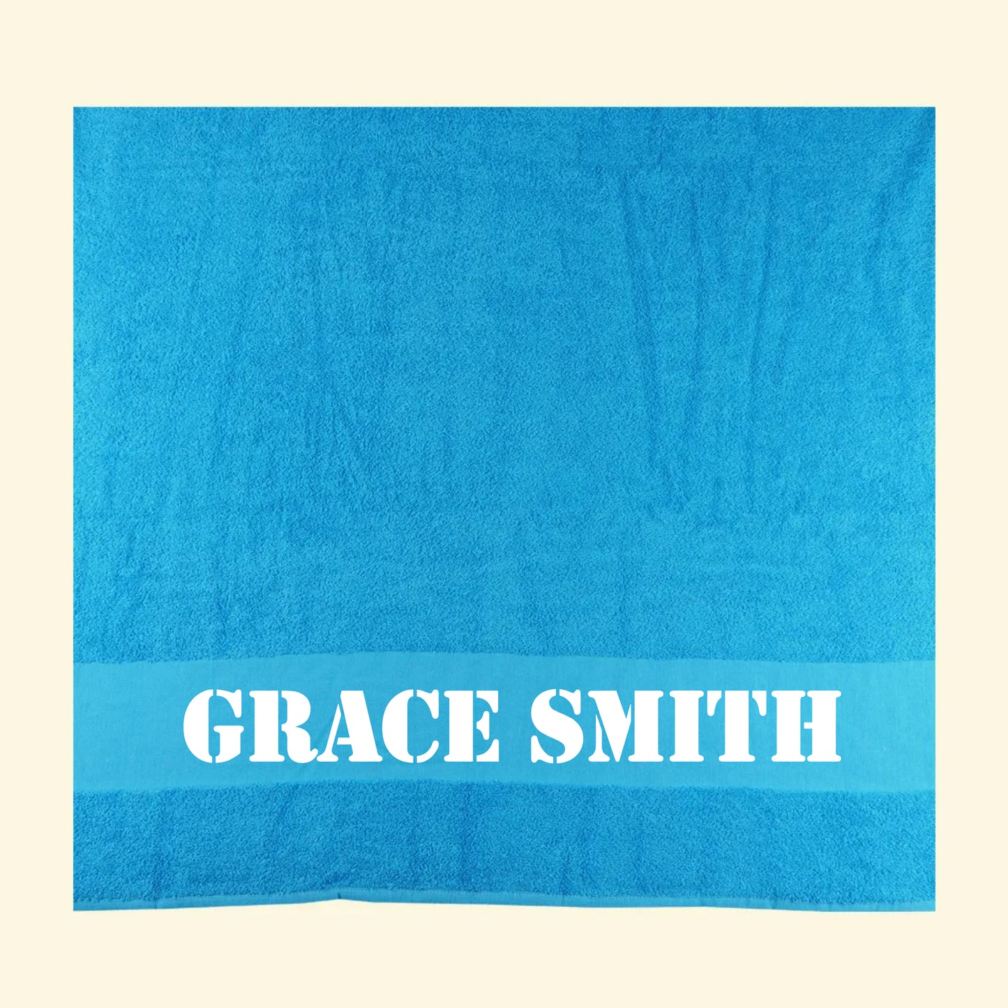 Aqua blue bath towel with the name Grace Smith printed on in an army style font