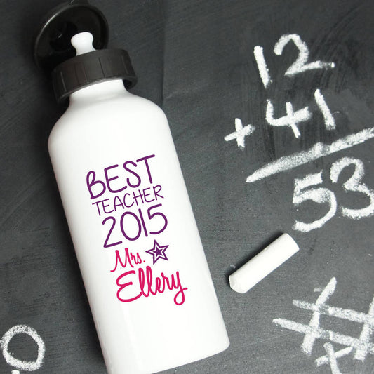 Aluminium water bottle with Best Teacher 2015 and the teachers name printed on the bottle. The bottle is white. The background is a chalkboard with sums on.