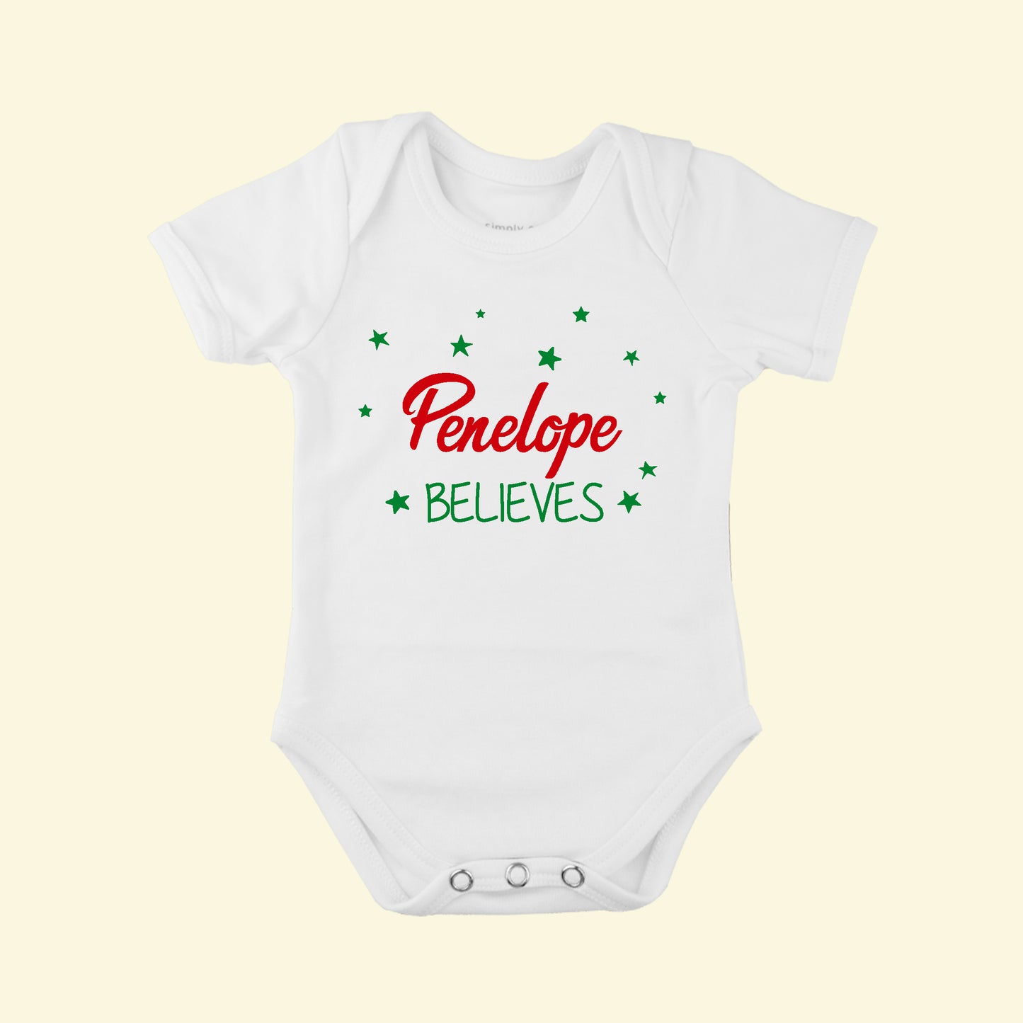 White babygrow with the name Penelope 
 and Believes underneath the name, surrounded by stars