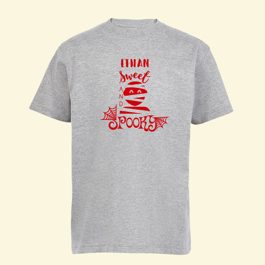 Grey t shirt with a mummy style halloween design and the text Sweet and Spooky with the name Ethan printed on the front of the t shirt in red.