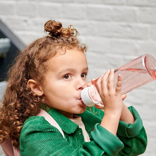 Girl drinking water from a pink Mepal campus water bottle