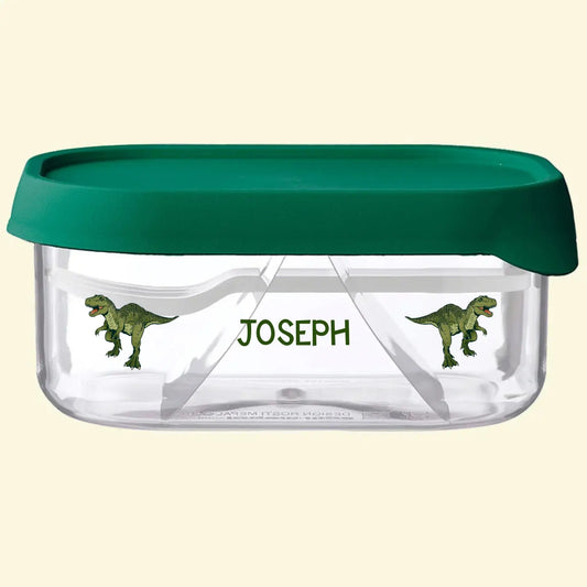 Mepal fruit box with a green lid, the name Joseph printed on the side with 2 dinosaurs each side of the name. The base of the snack box is see through
