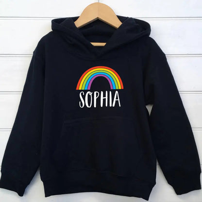 Navy hoodie with a colourful rainbow design and the name Sophia underneath printed on the front of the hoodie. The hoodie is on a wooden hanger set against a white background
