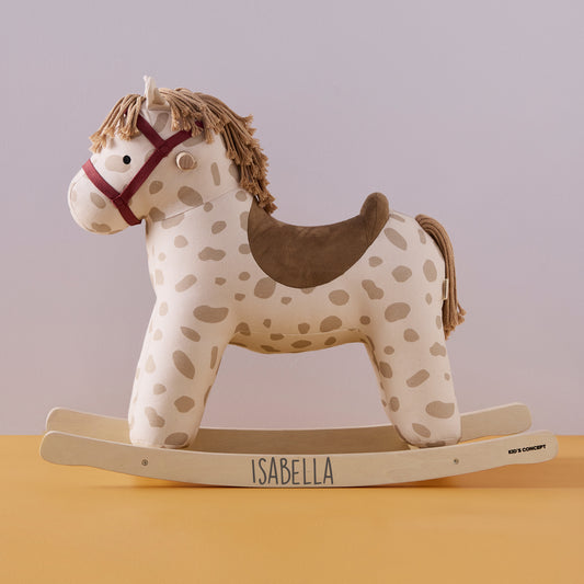 Dotty rocking horse toy with a red harness, brown saddle and a gorgeous mane and tail. The horse is cream and beige with a stylish dot design. The name Isabella is printed on the rockers