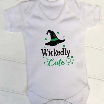 White babygrow with a cute halloween design. There is a witches hat and the text Wickedly Cute underneath, printed in black and green on the front.