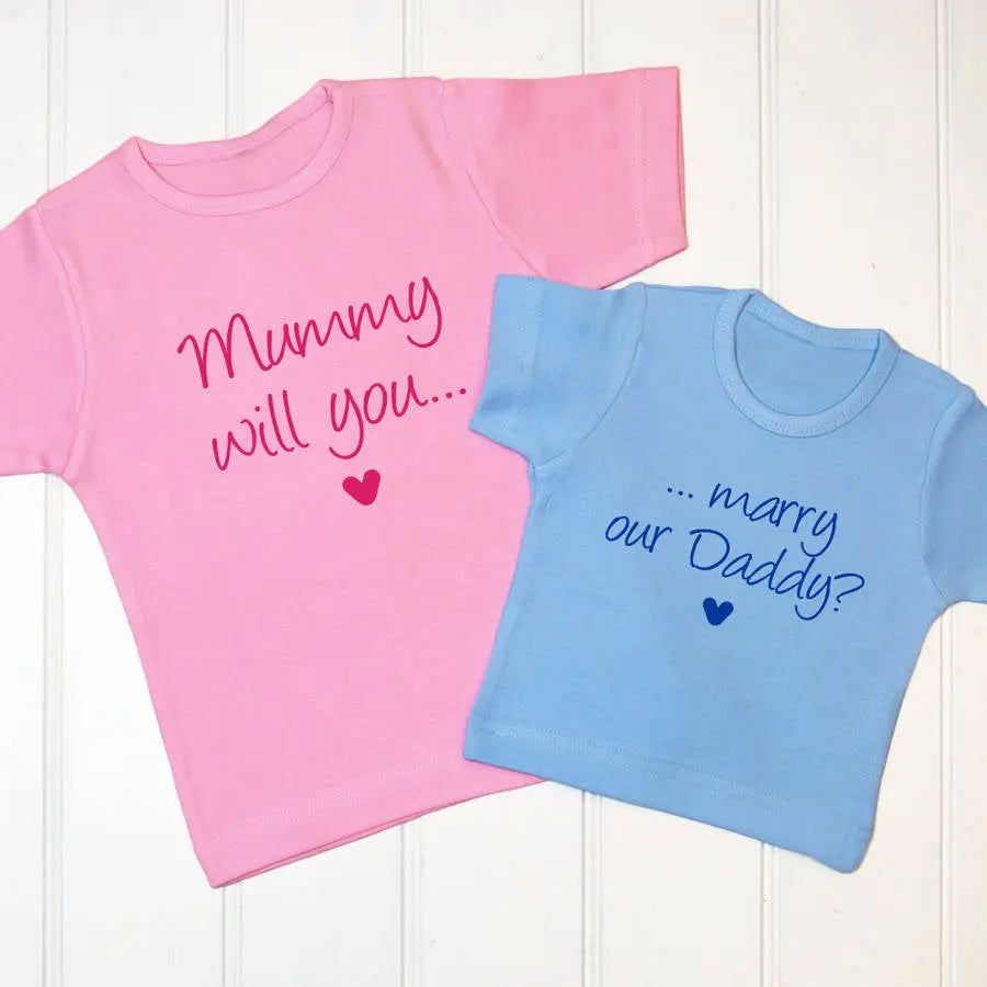 Two kids t shirts, one light pink with Mummy will you ... and a heart printed on the front with fuchsia pink, the other is light blue with ... marry our Daddy? and a heart printed in royal blue on the front. A lovely way to bring your children in to your proposal.