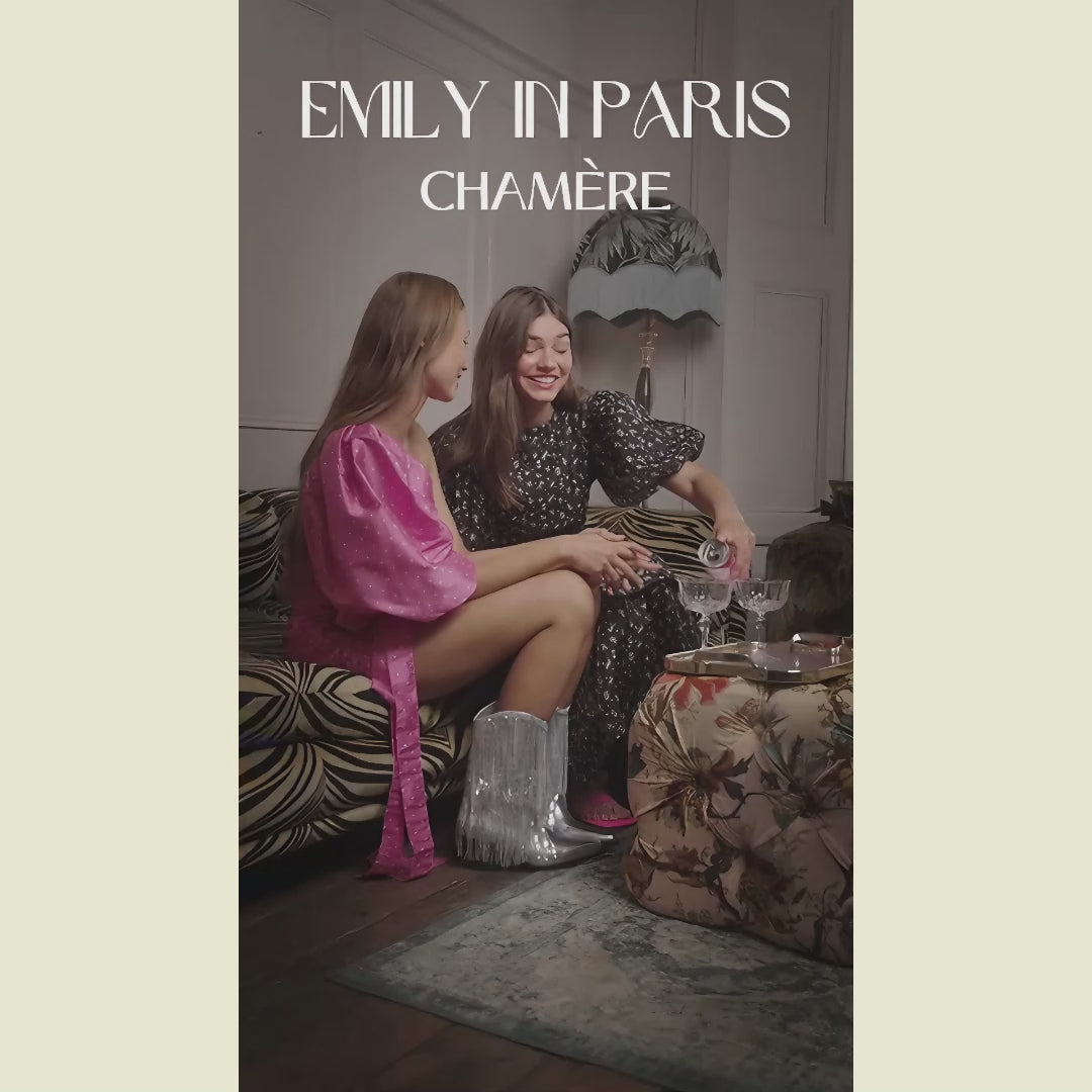 A short video of two women sitting on a sofa pouring Chamere into a couple of cocktail glasses. The text Emily in Pais Chamere is at the beginning of the video and at the end it says Sip like Emily