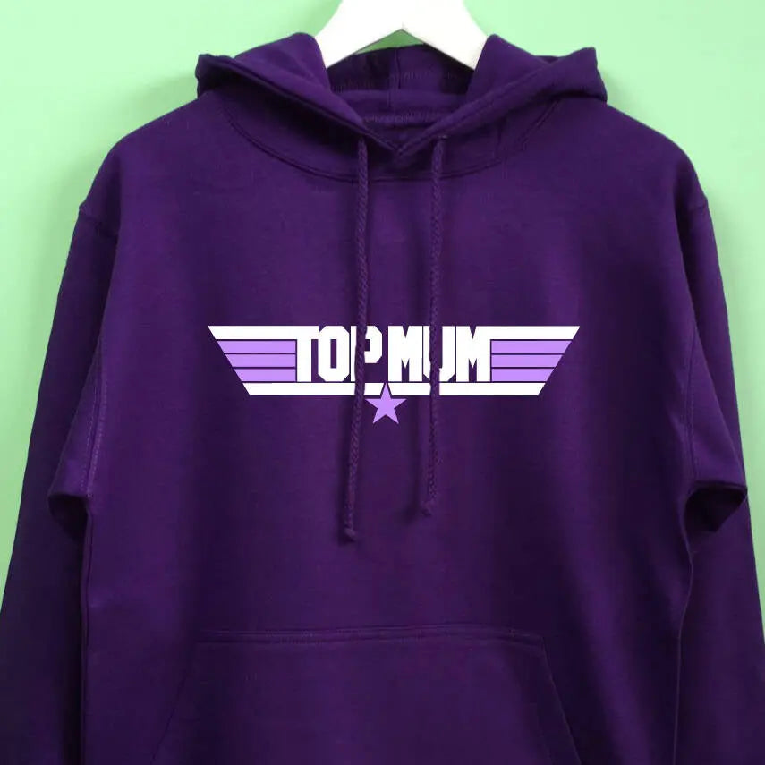 Purple hoodie hanging on a white hanger. On the front of the hoodie is a Top Gun style design that reads Top Mum in white and lilac stripes and a star.