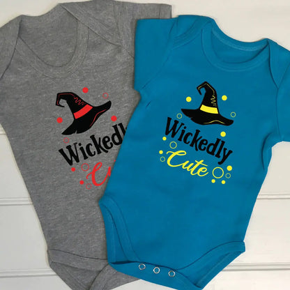 Two babygrows, one aqua blue and one grey. Both with a witches hat and Wickedly Cute printed on the front. The aqua blue has a black and yellow design and the grey babygrow has a black and red design. Great for Halloween or any other time of the year.