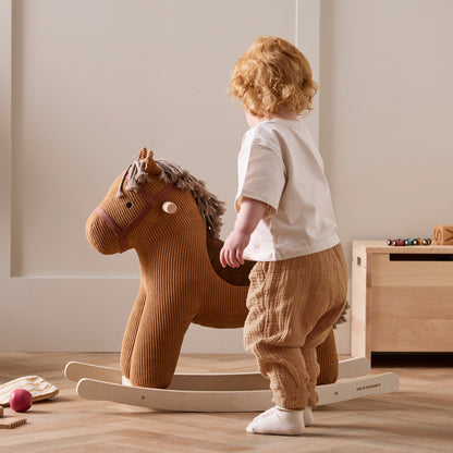 Child playing with rocking horse Vera