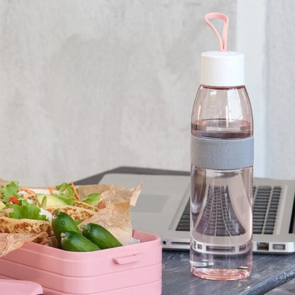 Nordic pink ellipse water bottle and lunch box, next to a laptop